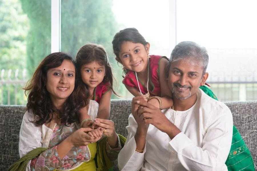Indian family together at home, weighing a decision to move abroad