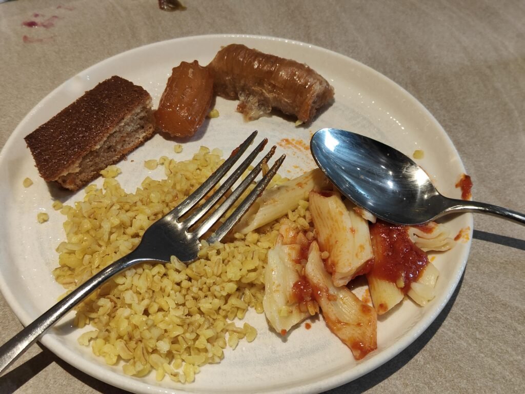 Bulgur pilaf, pasta and tulumba on a vegetarian plate in a Turkish airport lounge