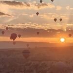 Hot air balloons drifting over the rock valleys of Cappadocia at sunrise