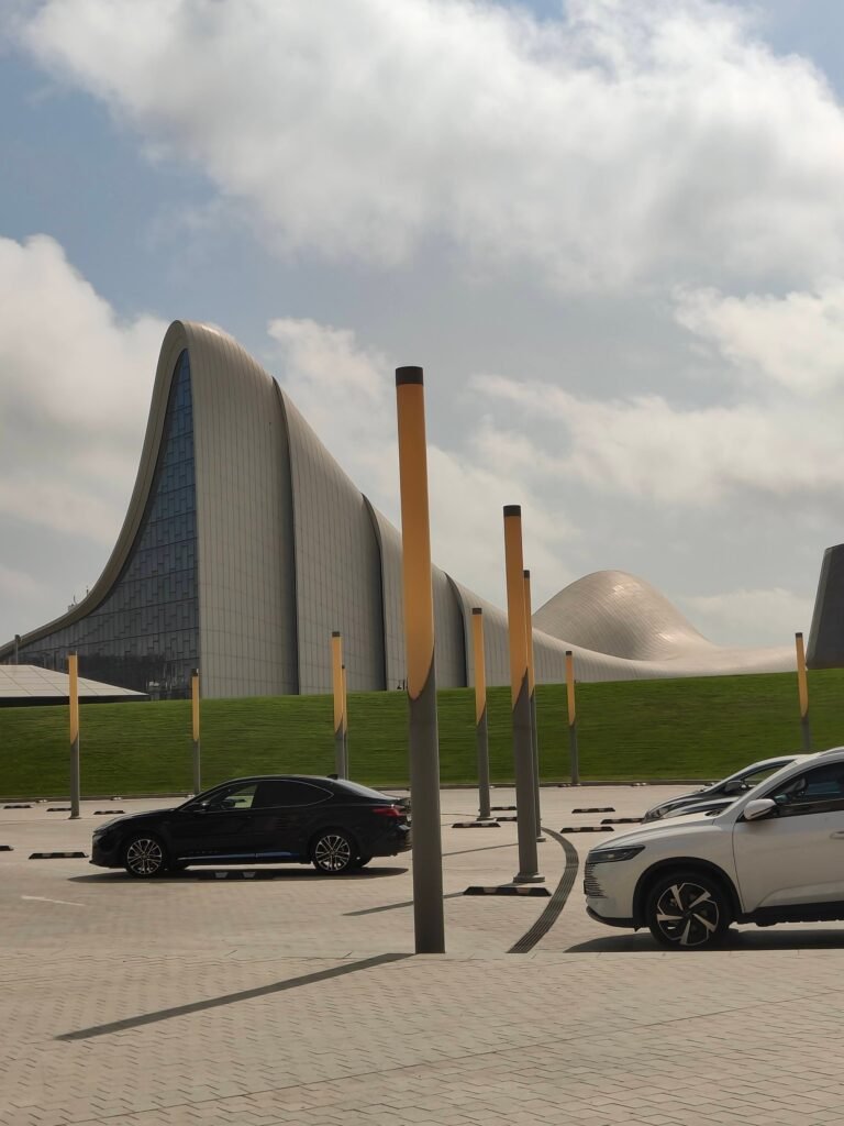 The Heydar Aliyev Center in Baku, a curved white building with no straight lines, seen across a car park