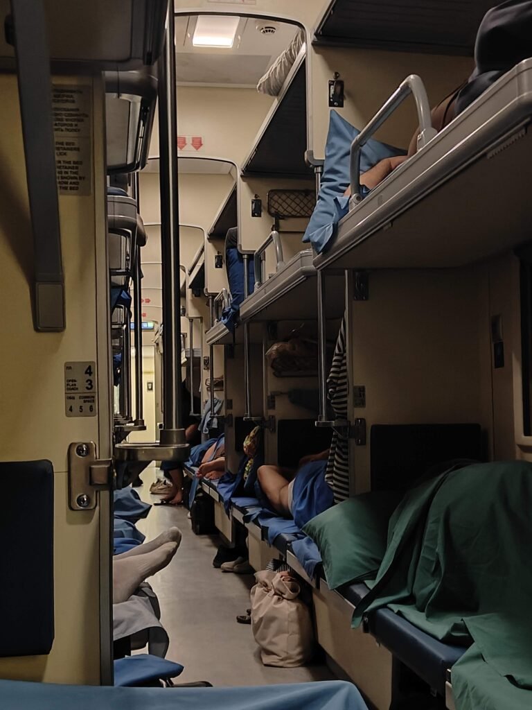 Third class open plan coach on the Tbilisi to Yerevan night train with passengers on their bunks