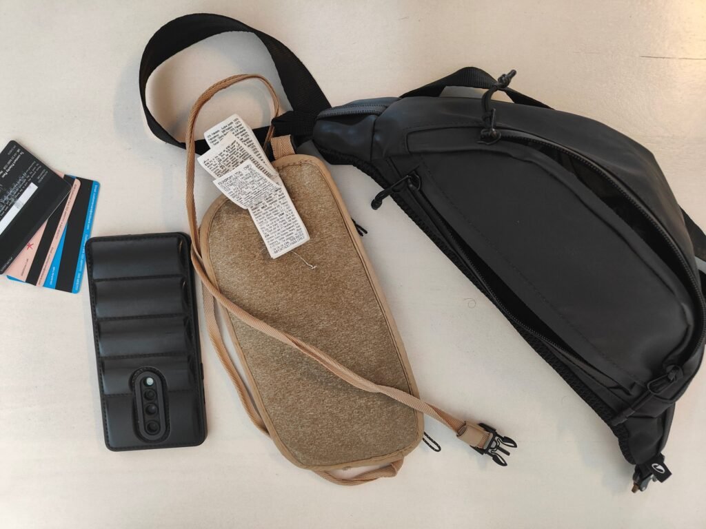 Spare phone, bank cards, a body pouch and a hip pouch laid out to protect your money abroad