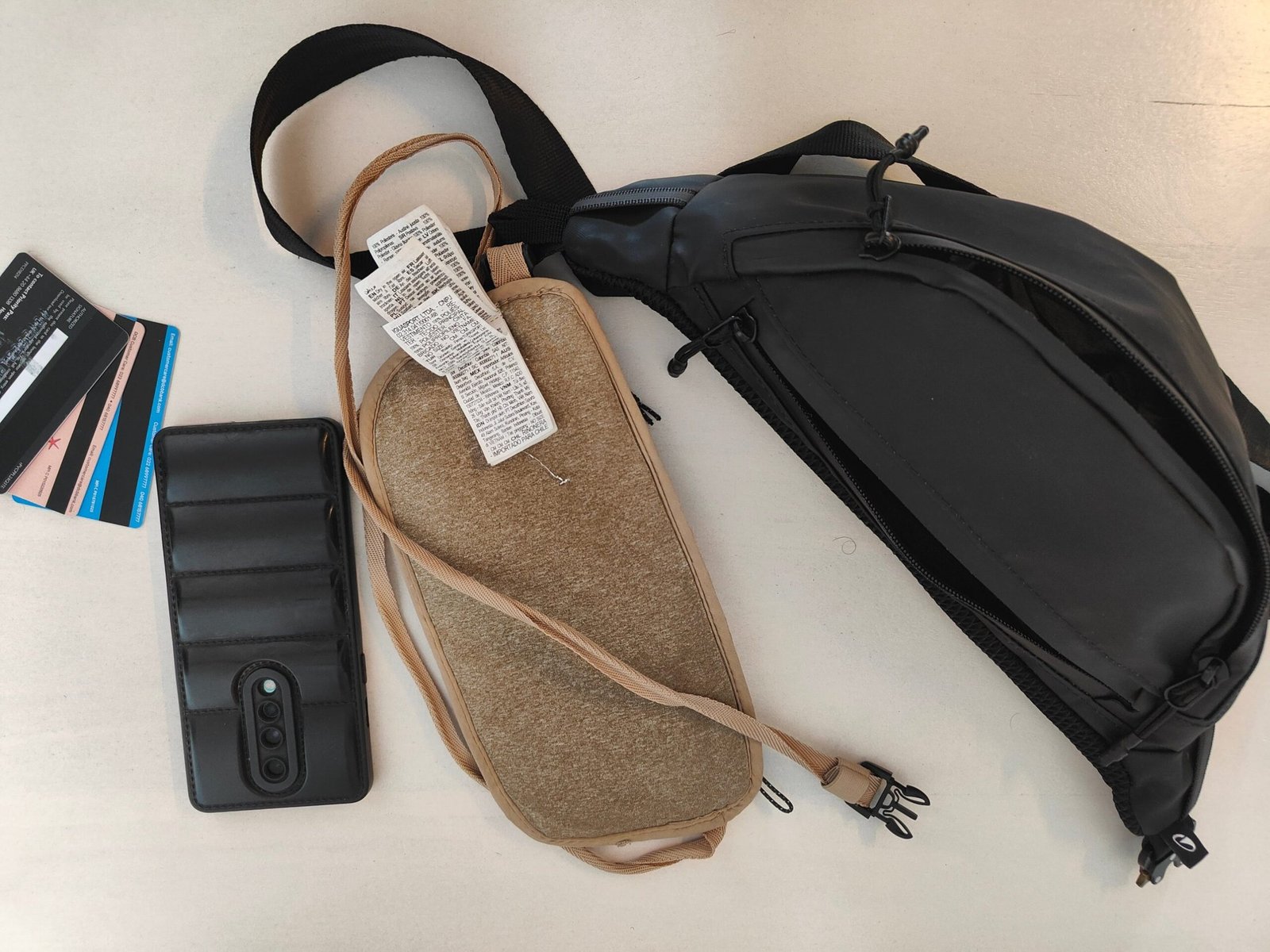 Spare phone, bank cards, a body pouch and a hip pouch laid out to protect your money abroad