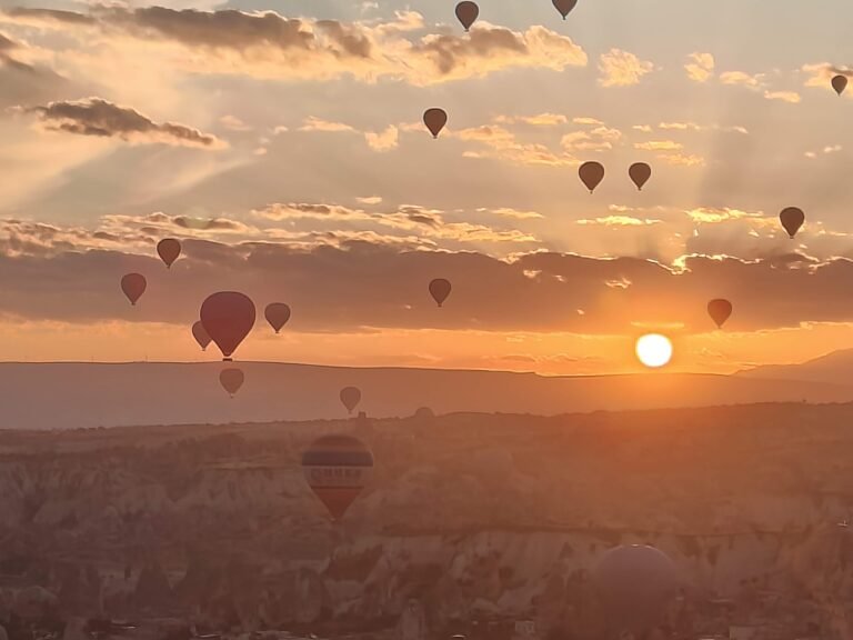 Hot air balloons drifting over the rock valleys of Cappadocia at sunrise
